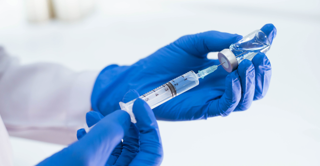 แพทย์ใส่ถุงมือกำลังเตรียมวัคซีน HPV ในหลอดฉีดยาเพื่อป้องกันมะเร็งปากมดลูก